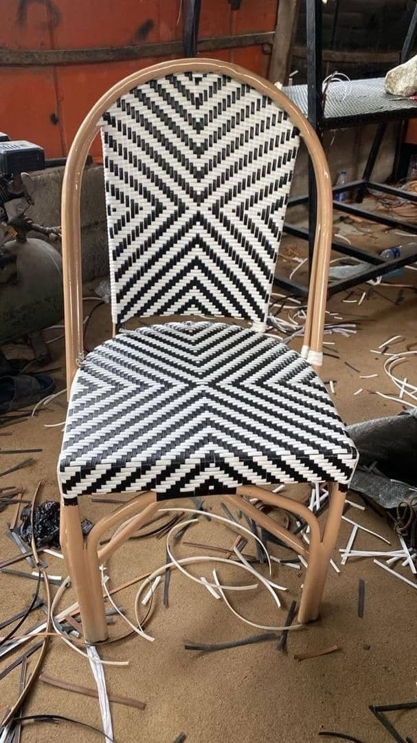 Handwoven rattan chair with a black-and-white patterned seat