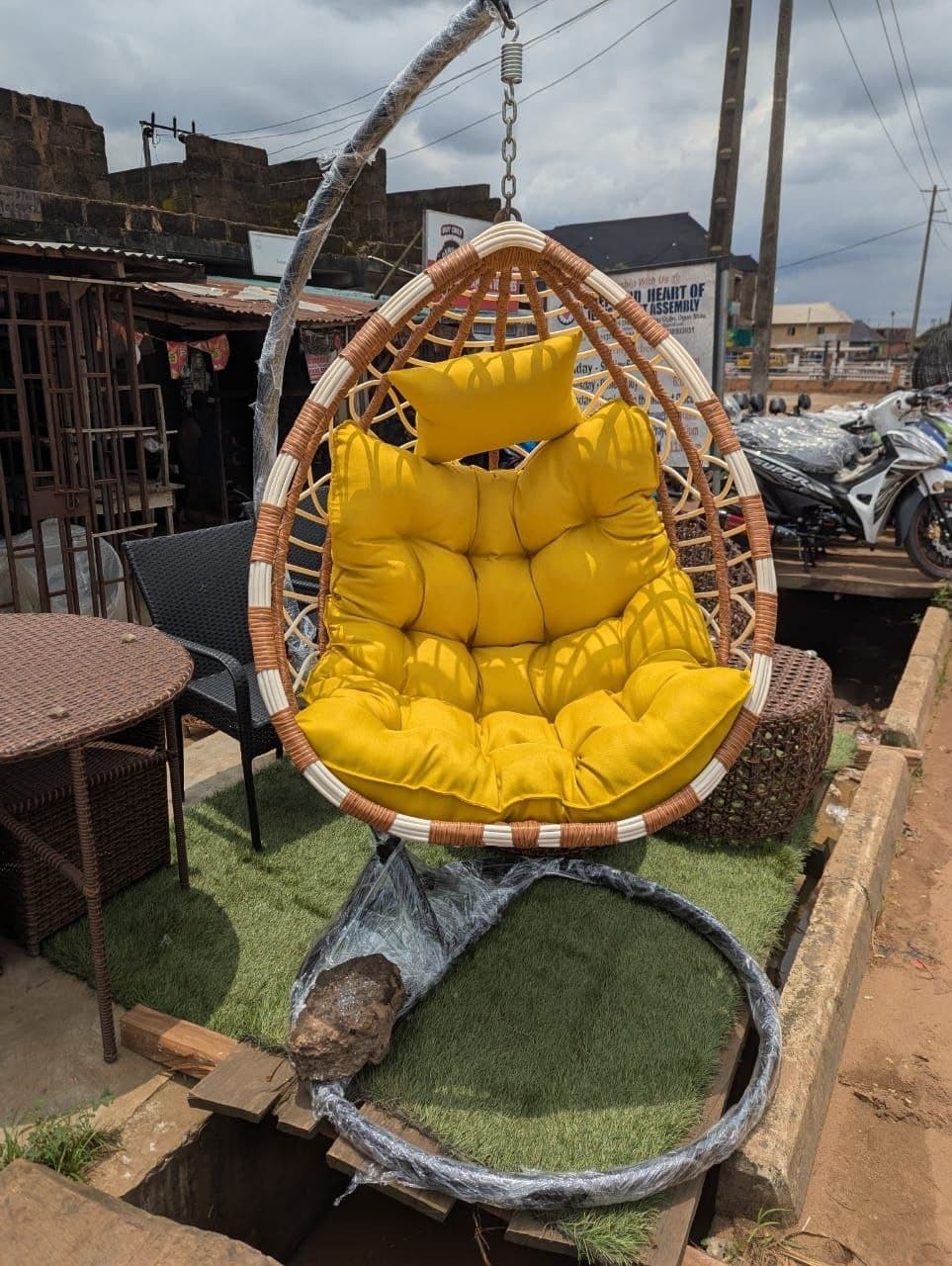 Rattan hanging chair with a yellow cushion