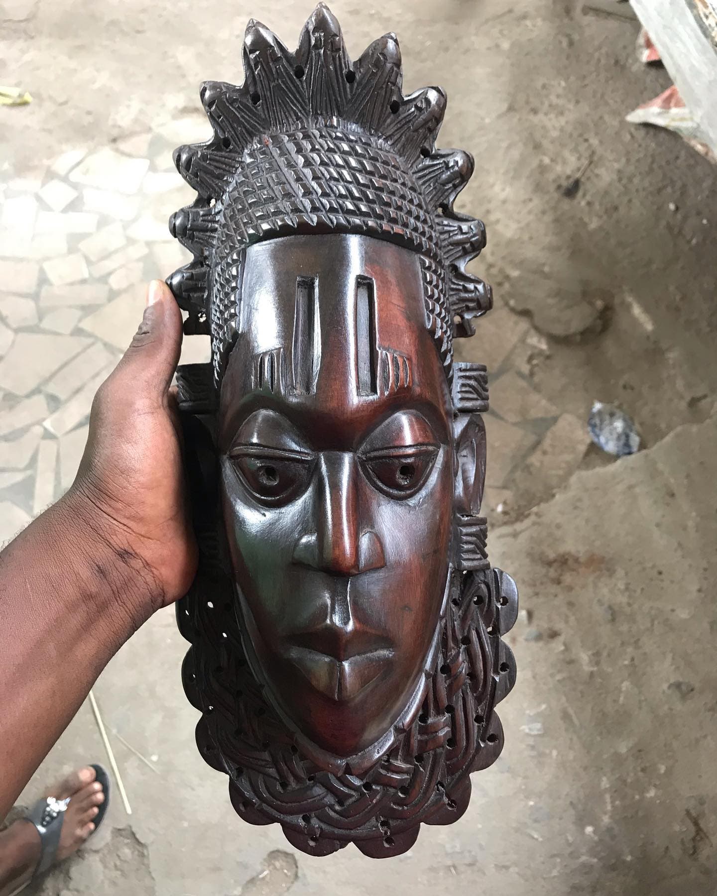 A collection of wooden masks displayed on black stands
