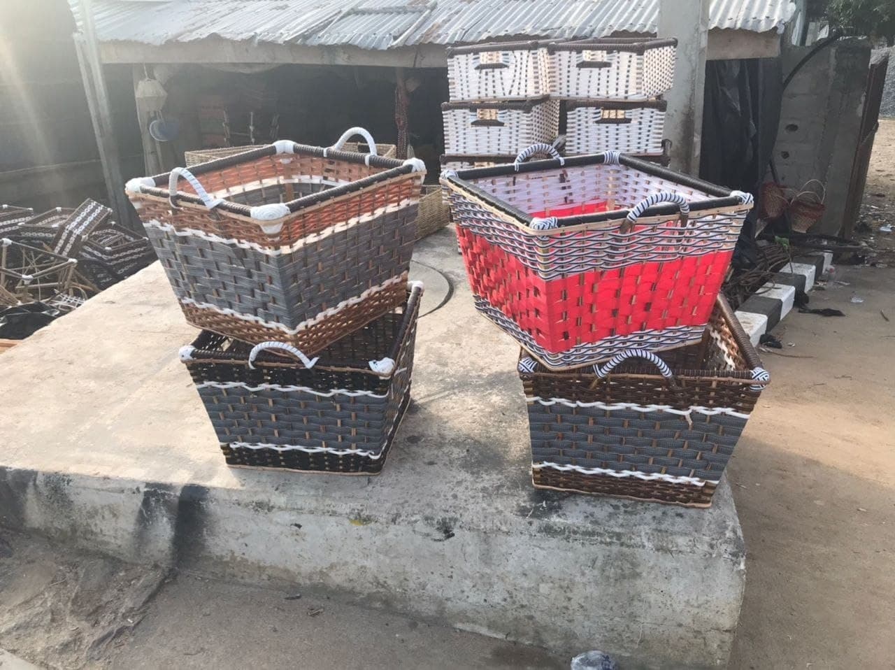 A set of handwoven storage baskets in natural and red finishes